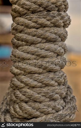 reeled rope on the coil. The texture of a rope. Thick brown rope rolled into a roll. Vertical layout. Background texture