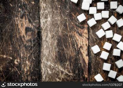 Refined cubes sugar. On a wooden background.. Refined cubes sugar.