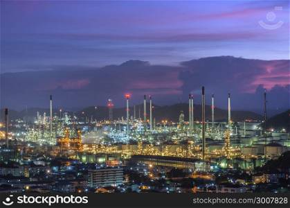 Refinery with tube and oil tank along twilight sky