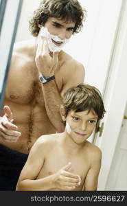 Reflection of a boy with his father applying shaving cream on their faces