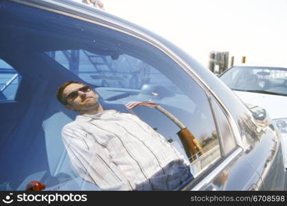 Reflection of a young man on a car window