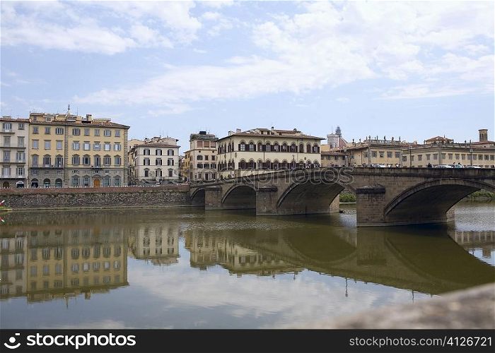 Reflection of an arch bridge in water, Ponte Santa Trinita Bridge, Arno River, Florence, Italy