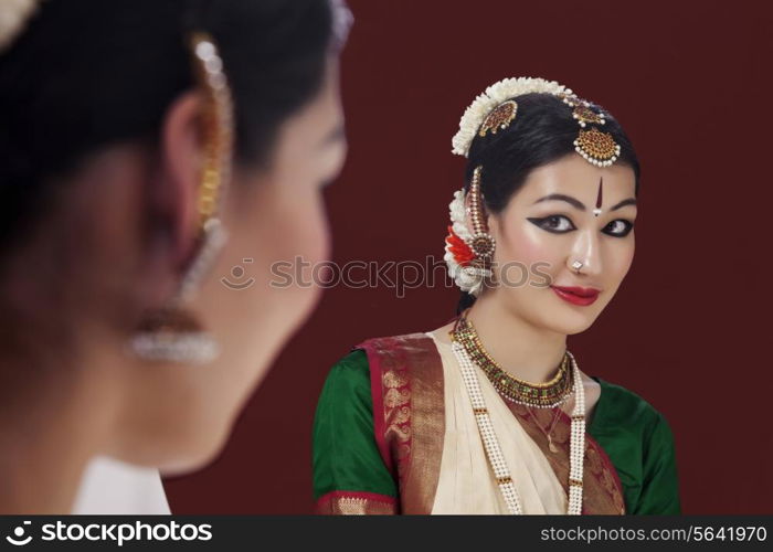 Reflection of beautiful Bharatanatyam dancer in mirror