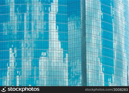 Reflection of blue sky with clouds in the windows. Facade of a modern office building. Modern industrial building with glass. Abstract background.