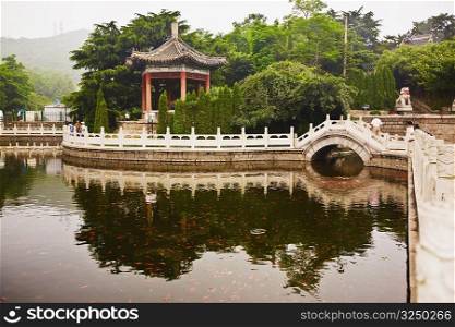 Reflection of bridge and trees in water, Zhanshan Temple, Qingdao, Shandong Province, China