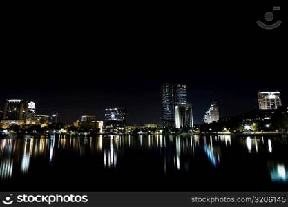 Reflection of buildings in a lake at night, Orlando, Florida, USA