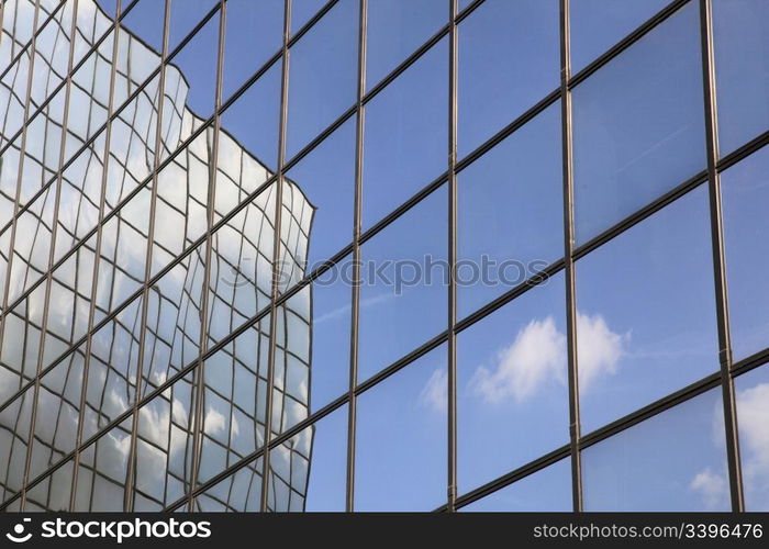 reflection of cloud and blue sky in glass facade