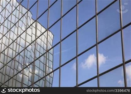 reflection of cloud and blue sky in glass facade