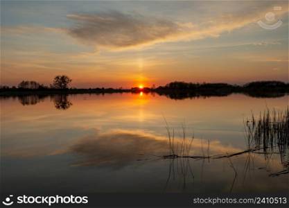 Reflection of cloud in a calm lake at sunset, Stankow, Lubelskie, Poland