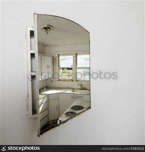 Reflection of empty abandoned dirty kitchen in mirror.