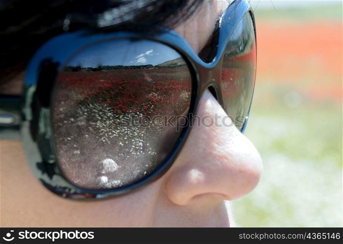 Reflection of field in woman&acute;s sunglasses