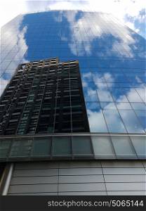 Reflection of office block with bright clouds near financial region of London city