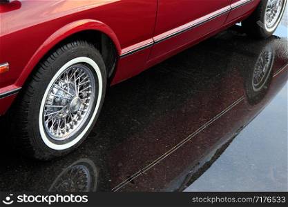 Reflection of red car in a puddle.