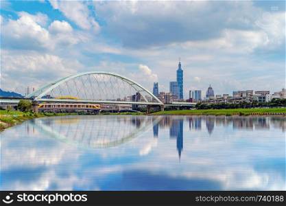 Reflection of river and Second MacArthur Bridge at Taipei Downtown, Taiwan. Financial district and business centers in smart urban city. Skyscraper and high-rise buildings at noon.