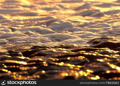 reflection of sun on basalt rocks at sunset