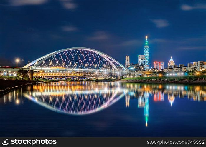 Reflection of Taipei bridge in downtown, Taiwan. Financial district and business centers in smart urban city. Skyscraper and high-rise buildings at night.