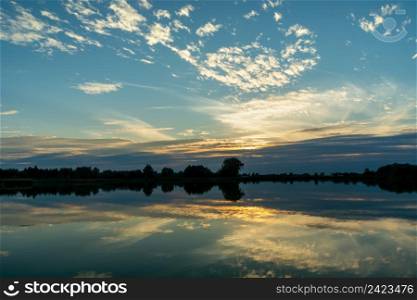 Reflection of the evening clouds in the lake water, Stankow, Lubelskie, Poland