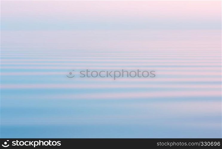 Reflection of the pink sunset in the flowing water surface with a white haze. Abstract seascape background in pastel sweet colors with motion blur filter. Space for copy and design.