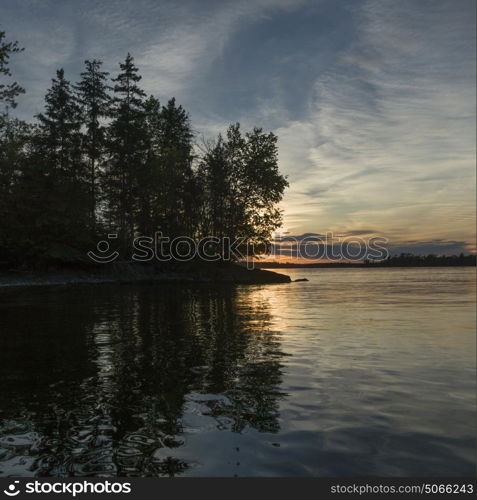 Reflection of trees and clouds in the lake, Lake of The Woods, Ontario, Canada