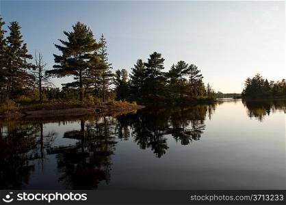 Reflection of trees in a lake, Lake of the Woods, Ontario, Canada