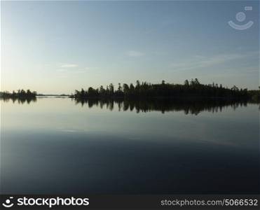 Reflection of trees on water, Lake of The Woods, Ontario, Canada