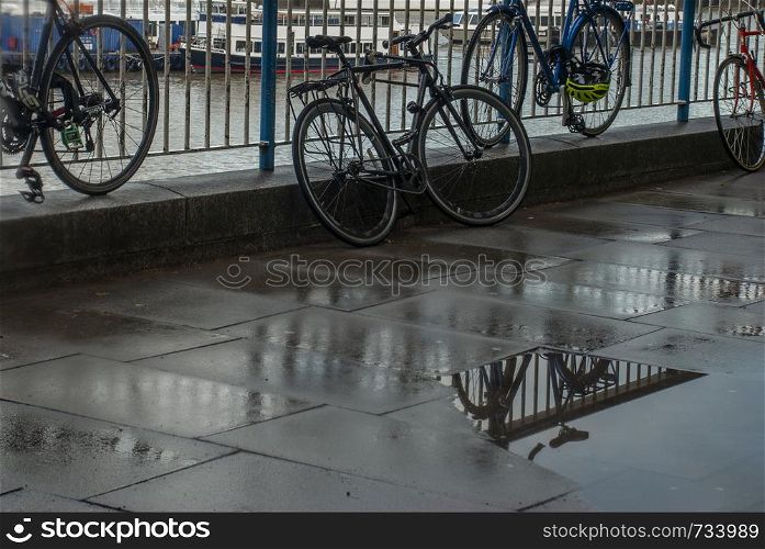 Reflections in the water of the path banks of the River Thames after rain. Suitable for background images.