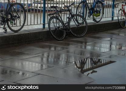 Reflections in the water of the path banks of the River Thames after rain. Suitable for background images.