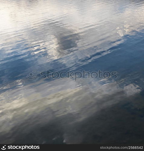 Reflections of cloud formations on rippling water.