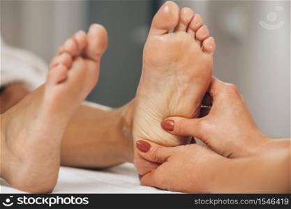 Reflexology Foot Massage. Practitioner applying pressure to client&rsquo;s foot stimulates energy and releases blockages that cause pain or illness. Reflexology Foot Massage