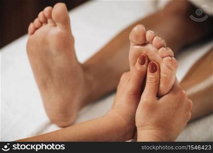 Reflexology Foot Massage. Practitioner applying pressure to client&rsquo;s foot stimulates energy and releases blockages that cause pain or illness. Reflexology Foot Massage