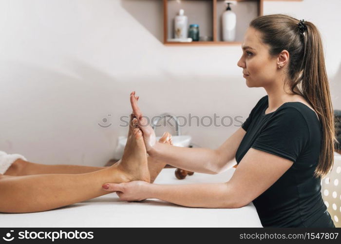 Reflexology treatment - Therapist massaging client?s foot at a beauty center. Reflexology Treatment