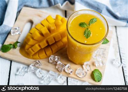 Refreshing and healthy mango smoothie in a glass with mango