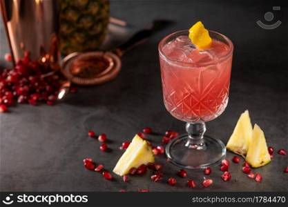 refreshing and light pomegranate and pineapple summer cocktail with ice cubes