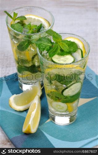 Refreshing cocktail cucumber mojito with lemon slices and mint