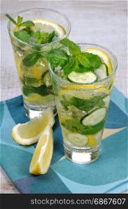 Refreshing cocktail cucumber mojito with lemon slices and mint