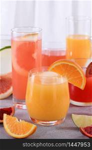 Refreshing freshly squeezed orange juice among fresh detox citrus juices from Sicilian orange, grapefruit, lime