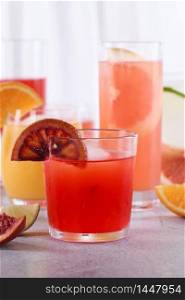 Refreshing freshly squeezed Sicilian orange juice among fresh detox citrus juices from orange, grapefruit, lime