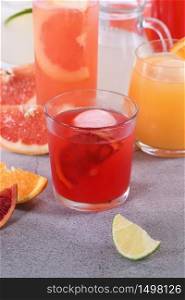 Refreshing freshly squeezed Sicilian orange juice among fresh detox citrus juices from orange, grapefruit, lime