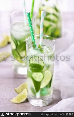 Refreshing infused water with cucumber, mint and lime . Summer beverage cocktail lemonade. Healthy drink and detox concept.