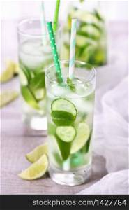 Refreshing infused water with cucumber, mint and lime . Summer beverage cocktail lemonade. Healthy drink and detox concept.