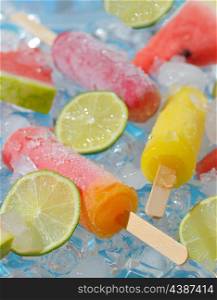 Refreshing lime and fruits ice pops on ice cubes