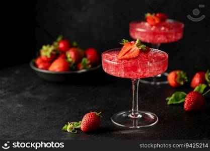 Refreshing summer drink with strawberry slices and fresh berries on dark background. Strawberry cocktail in a glass. Strawberry cocktail in a glass