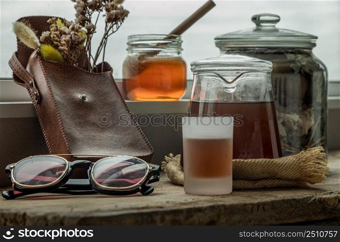 Refreshing with Chinese herbal tea (Jub Lieng) served with honey on old wooden table with city view. Herbal plant and healthy drinks concept, Selective focus.