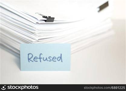 Refused; Stack of Documents on white desk and Background.