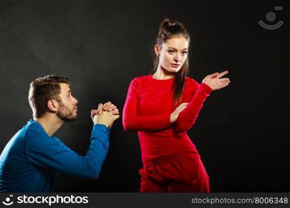 Regretful man husband apologizing upset woman wife. Husband apologizing upset angry wife. Man asking woman for forgivness. Boyfriend trying to convince girlfriend. Conflicted couple in studio on black. Relationship problem.