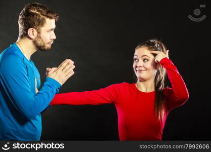 Regretful man husband apologizing woman wife.. Husband apologizing wife. Man asking woman for forgivness. Boyfriend trying to convince girlfriend. Conflicted couple in studio on black. Relationship problem.