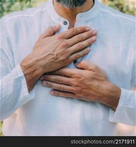 Reiki spiritual self-treatment healing session. Man holding hands above the heart chakra. . Reiki Self-Treatment Healing