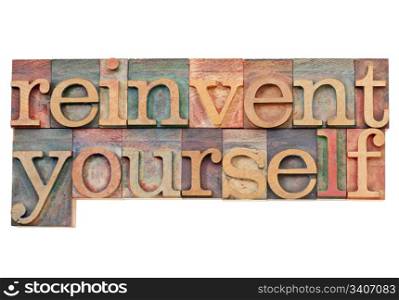 reinvent yourself - personal development concept - isolated text in vintage wood letterpress printing blocks stained by color inks