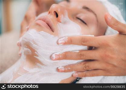 Rejuvenating face mask, beautiful woman getting a facial treatment in beauty salon. . Rejuvenating Cosmetic Face Mask 