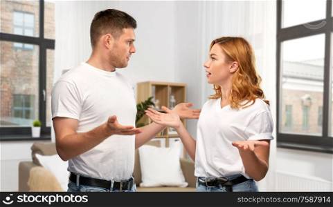 relationship difficulties, conflict and emotions concept - unhappy couple having argument over messy home room background. unhappy couple having argument at messy home